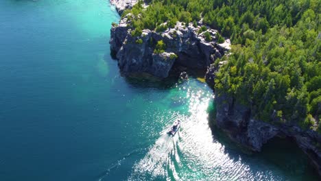 Vista-Aérea-De-Un-Barco-A-Motor-En-Una-Costa-Rocosa-En-La-Bahía-Georgiana,-Península-De-Bruce,-Ontario,-Canadá