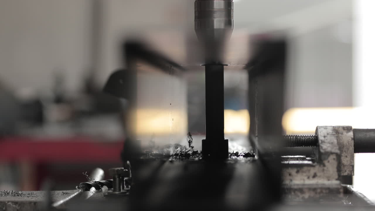 금속 조각에 드릴 비트 드릴링 구멍의 금속 부스러기 - 닫기, 슬라이더 샷