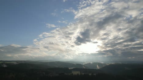 Toma-Panorámica-De-Un-Dron-De-Una-Zona-Montañosa-Con-Niebla-Que-Se-Evapora-De-Las-Colinas-Y-Nubes-Dramáticas-Después-De-La-Lluvia