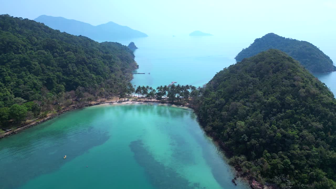 Scenic aerial view of lush green hills and turquoise waters on Koh Chang Ngam Island. Unbelievable aerial view flight descending drone