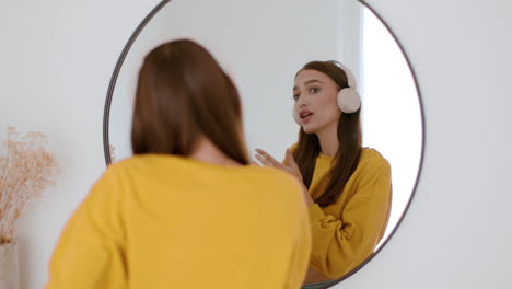 woman dancing in front of mirror wearing headphones