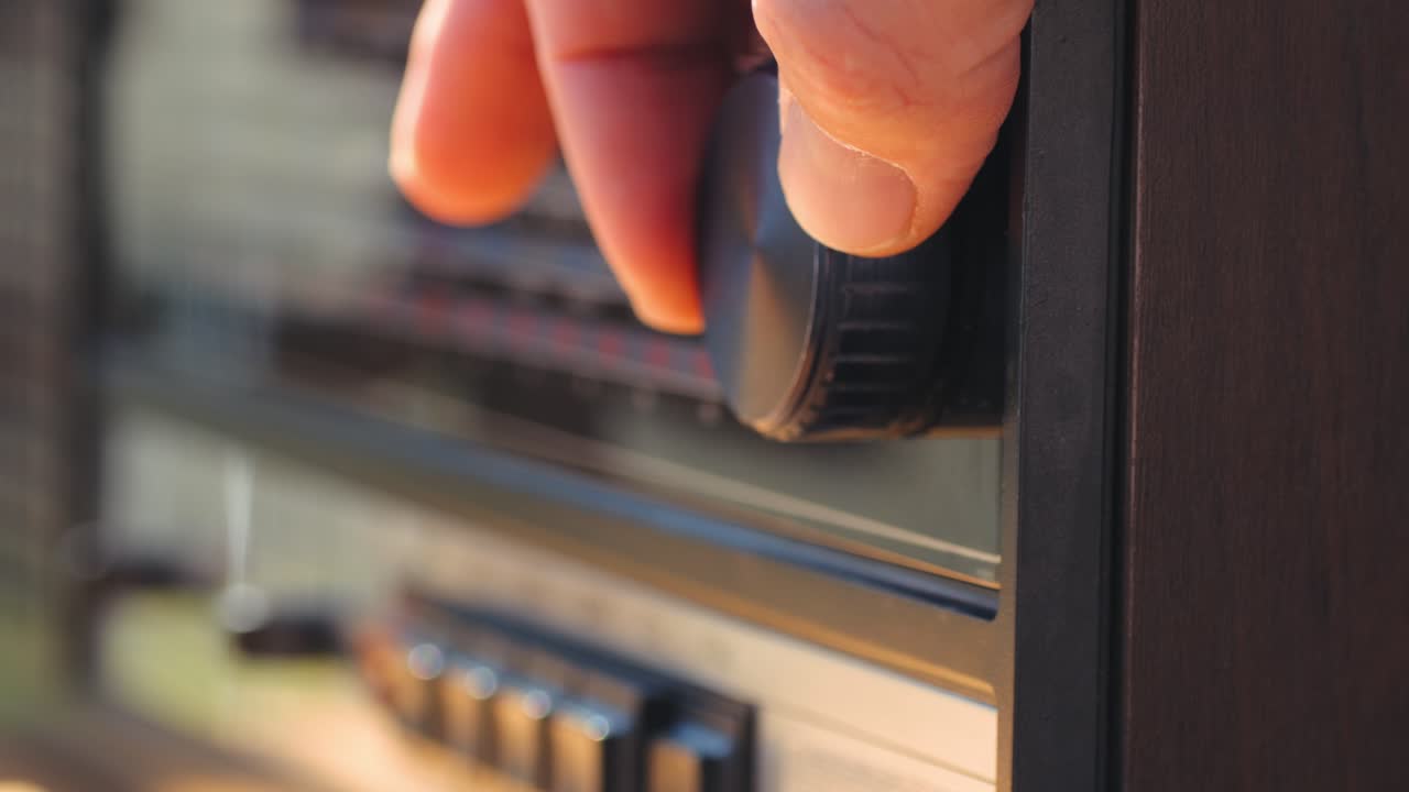 Vecchia radio AM FM retrò a valvole, mano che cambia stazione, lettore musicale vintage a valvole