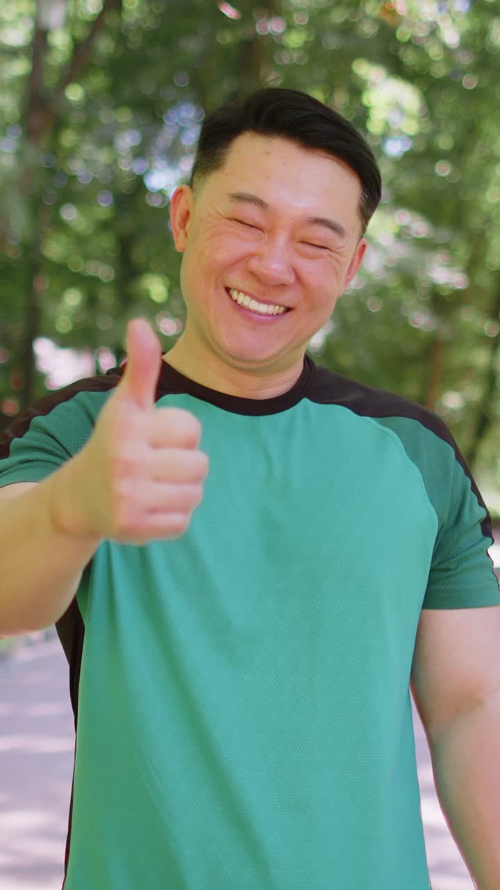Atlético sonriente corredor en forma feliz por el logro de la maratón mostrando el pulgar hacia arriba como un gesto