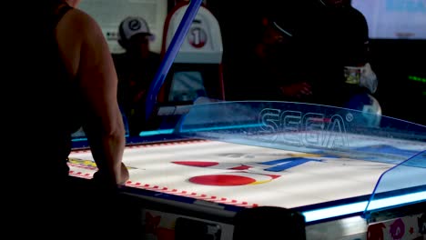 players engaged in an intense air hockey match