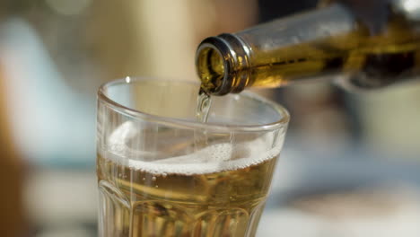 close up shot of an unrecognizable man holding glass and pouring beer into it