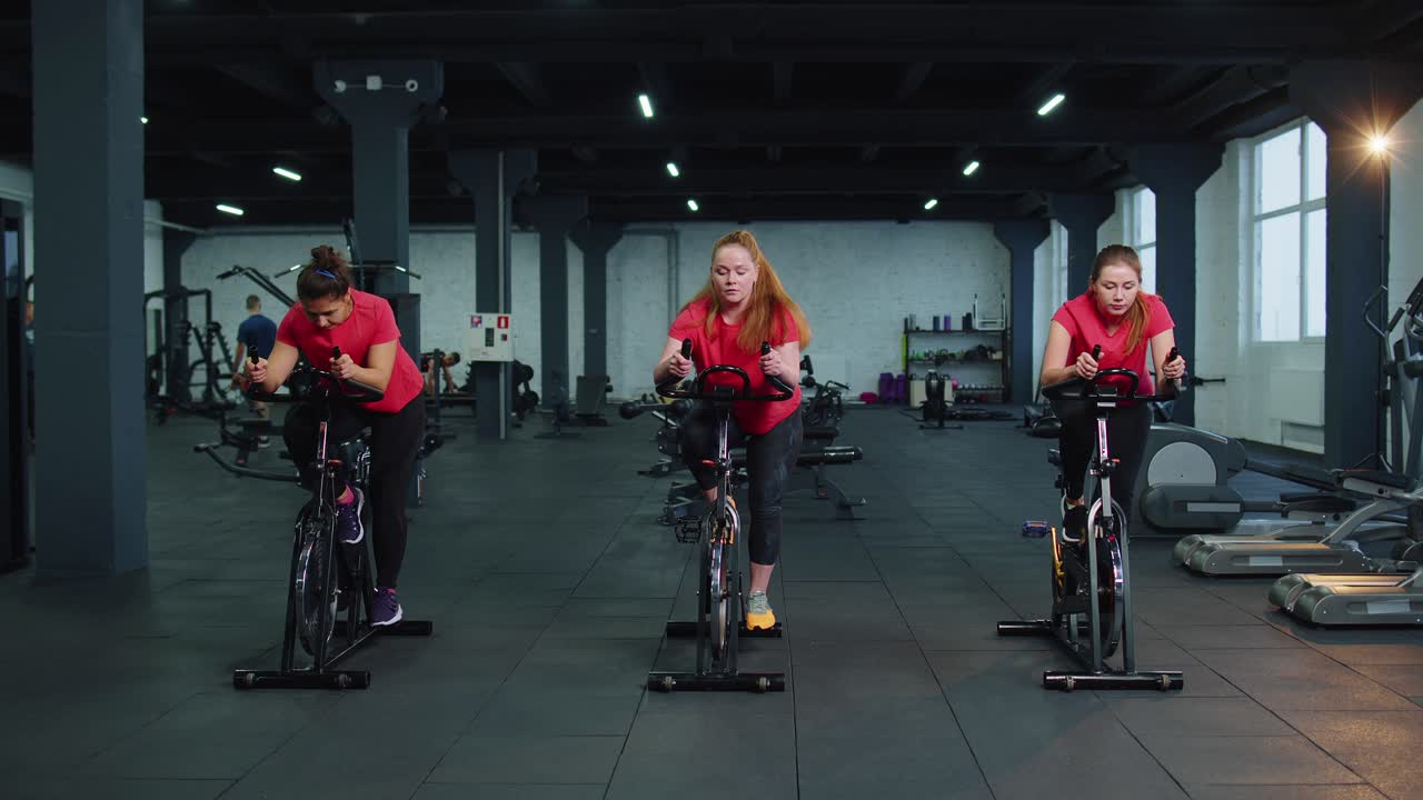 Group of girls performs aerobic training workout cardio routine on bike simulators cycle training
