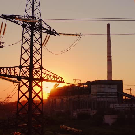 industrial high voltage electricity tower. silhouette of high voltage electric tower on sunset time. industrial factory against the evening sky on sunset time background.