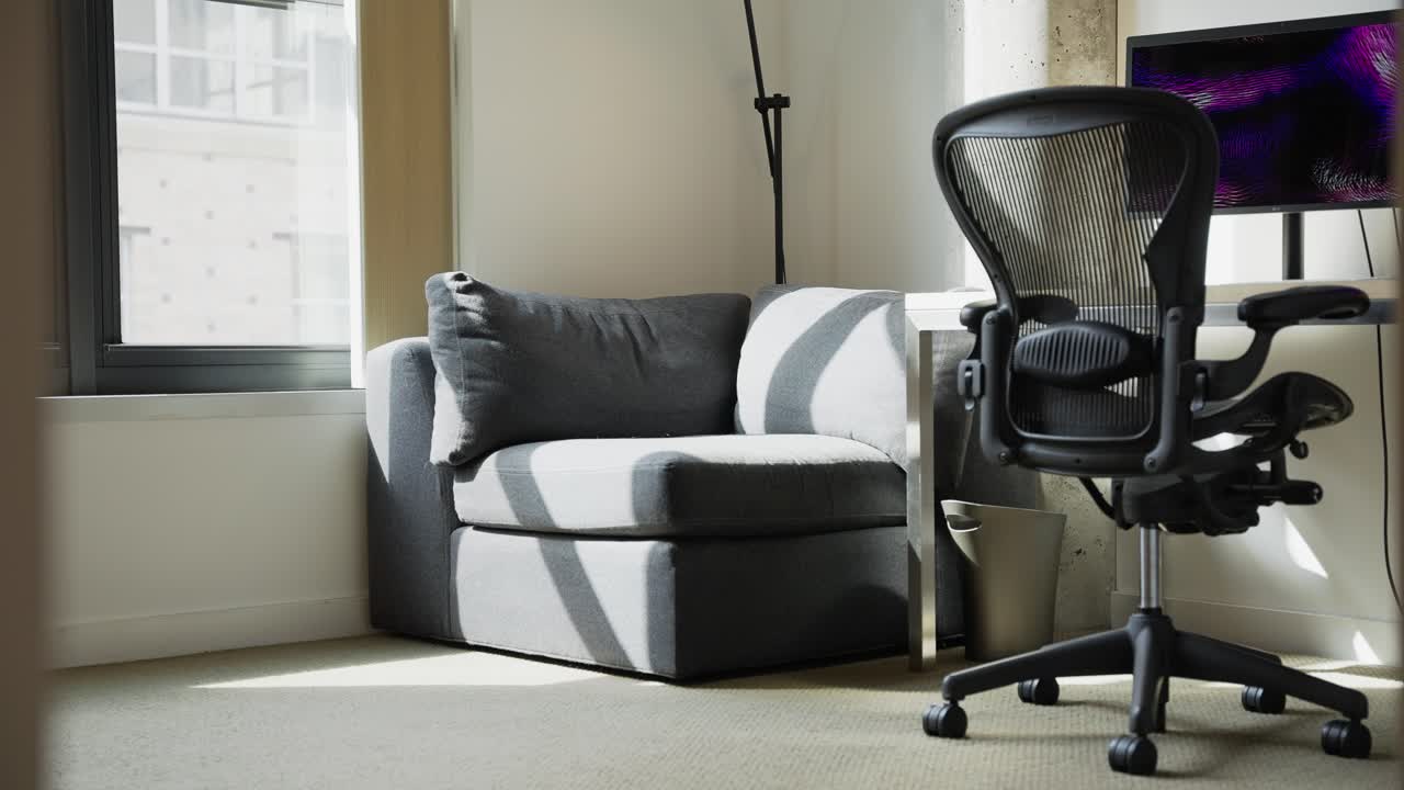 책상과 컴퓨터가 있는 작은 소파와 사무용 의자