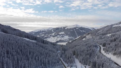 drone flies slowly over snow covered trees in austria