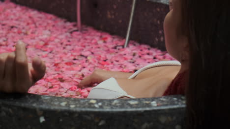 mujer disfrutando de un baño de pétalos de flor