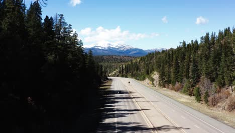 conducción de automóviles en la carretera con una majestuosa cordillera alta en segundo plano