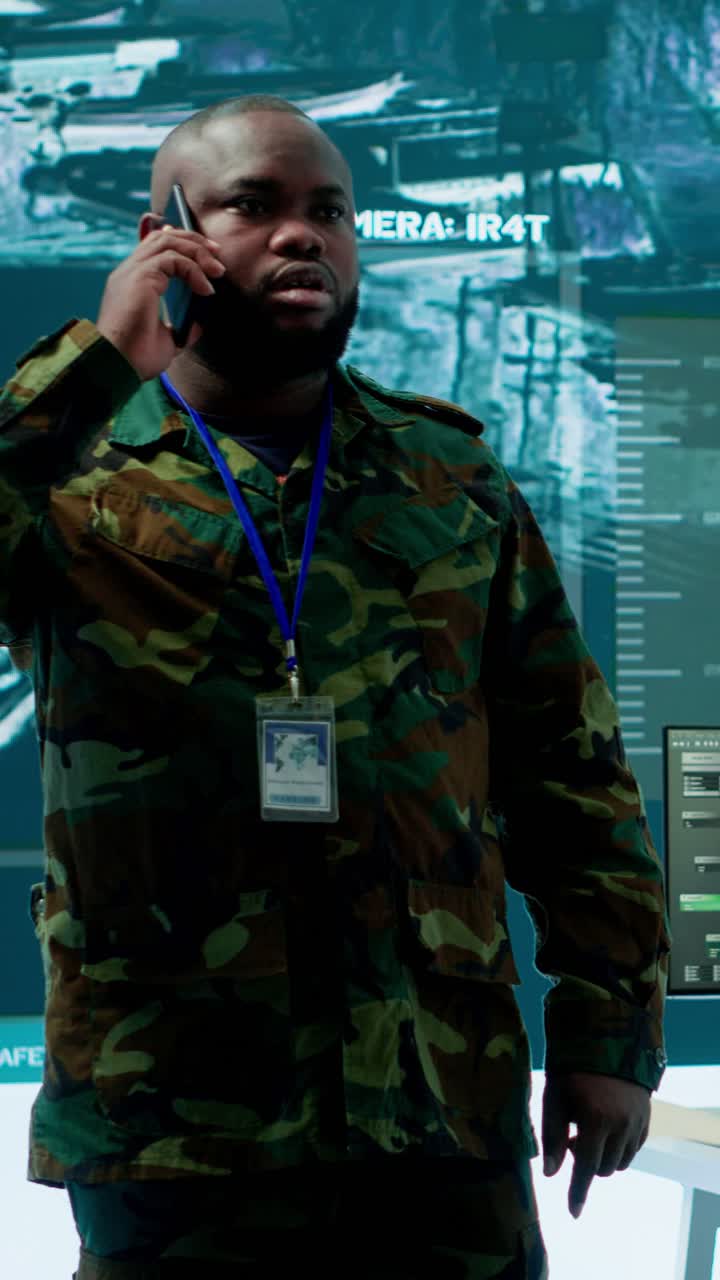 Video verticale: Specialista militare gestisce operazioni nazionali con il suo team in un centro di controllo.