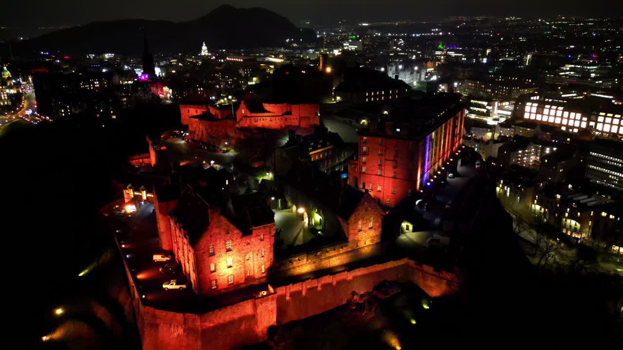 Aerial view of the Edinburgh Castle on Castle Rock at night with the illuminated city on the background Edinburgh, Scotland