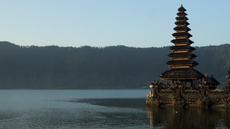 panorama shot of pura segara ulun danu batur temple at the volcanic lake batur on bali in indonesia with view of the lake and the beautiful landscape of indonesia during golden hour