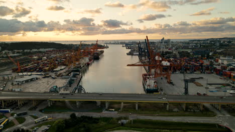 aerial view of gdynia cargo terminal at sunset, industrial port with containers, trucks, cranes, and cargo ships