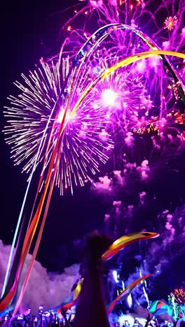 colorful fireworks bursting in the night sky, illuminating a jubilant crowd waving flags, creating a lively and festive atmosphere filled with joy and excitement during the celebration