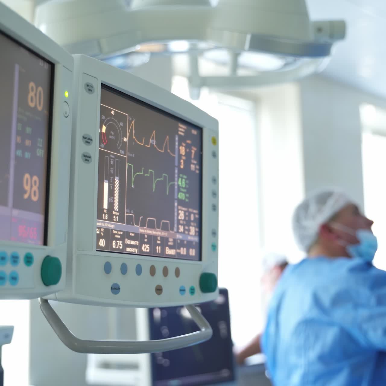 I parametri ECG del paziente sul monitor in sala operatoria. Battito cardiaco e pressione sanguigna sullo schermo. Un chirurgo esegue un'operazione in sala operatoria.