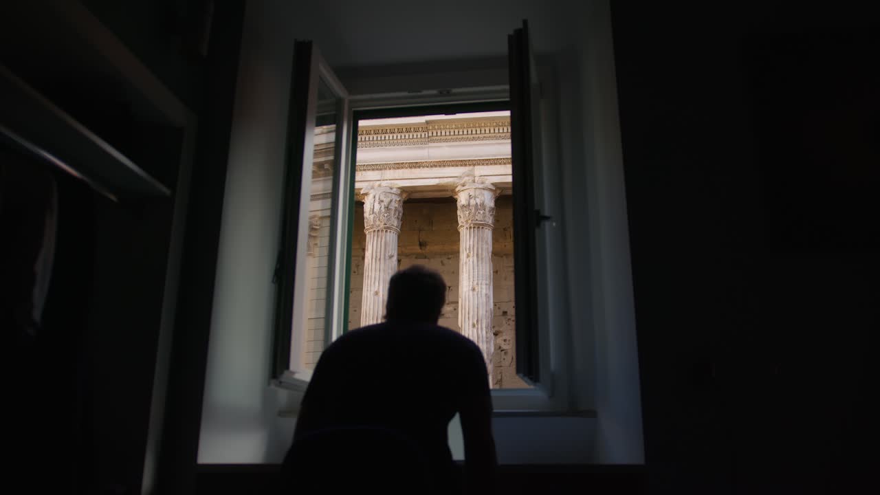 Man gazing out from hotel window towards the Pantheon in Rome, Italy