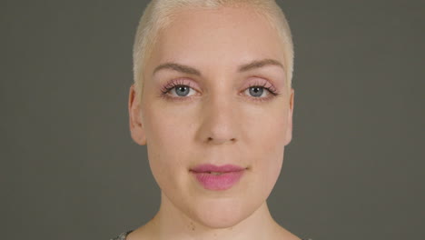 female model poses for camera in front of grey backdrop 03