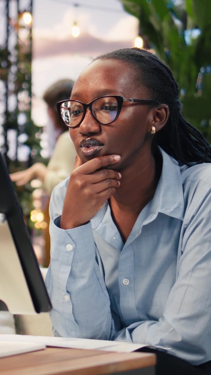 Vertical video Close up of businesswoman using tablet on stand on rooftop workspace table