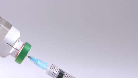 primer plano del vial de insulina y la jeringa sobre un fondo gris con espacio para copiar, cámara lenta