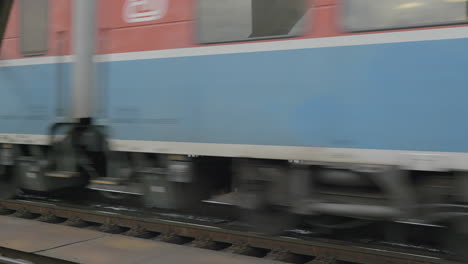 passenger train going over a bridge at speed with prague in the background