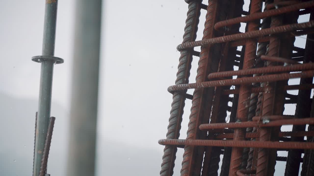 Close up in the rain of the rebar framework used for reinforcing concrete in construction