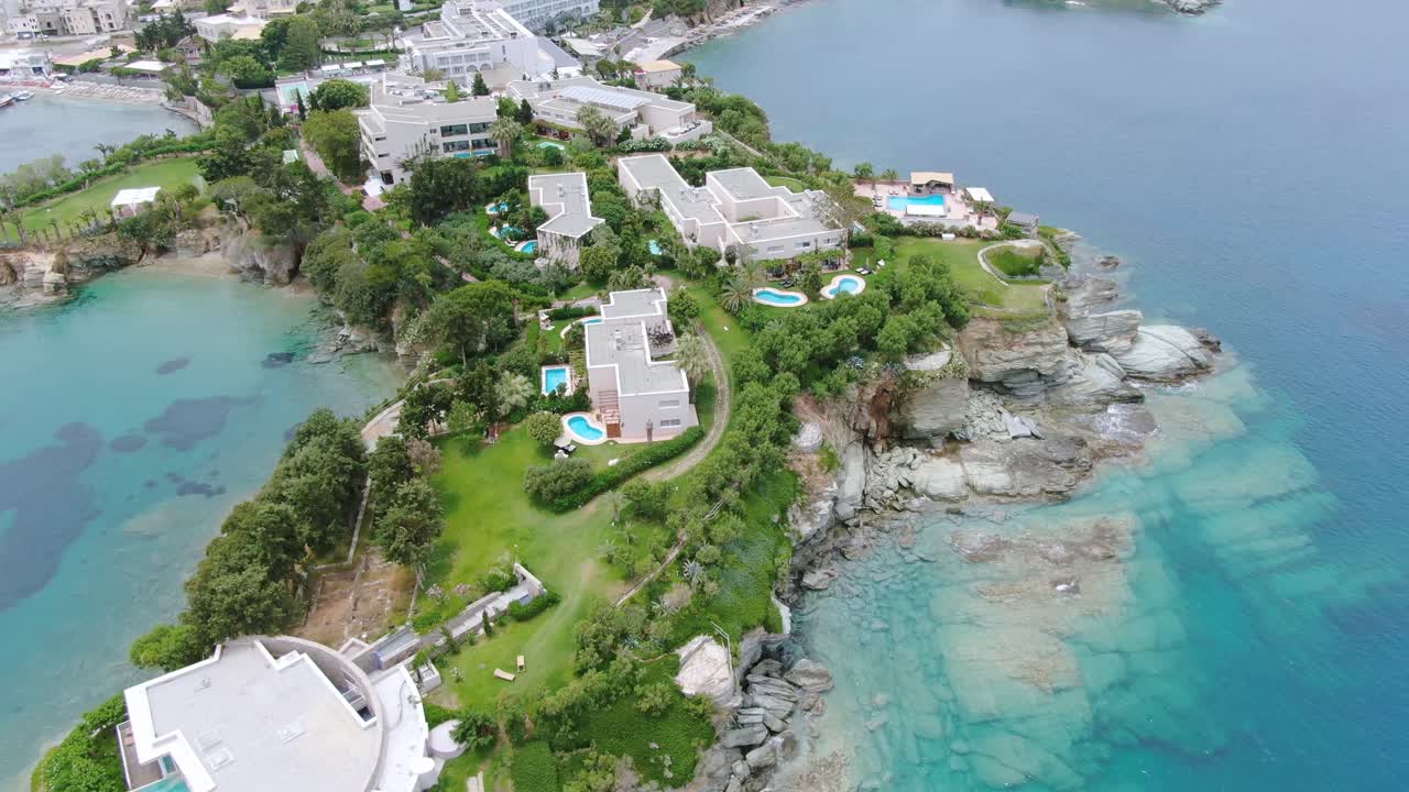 Wide angle dolly out drone aerial shot of beautiful beaches, coastlines, resorts, and hotels in Creta Islands, Greece during the day