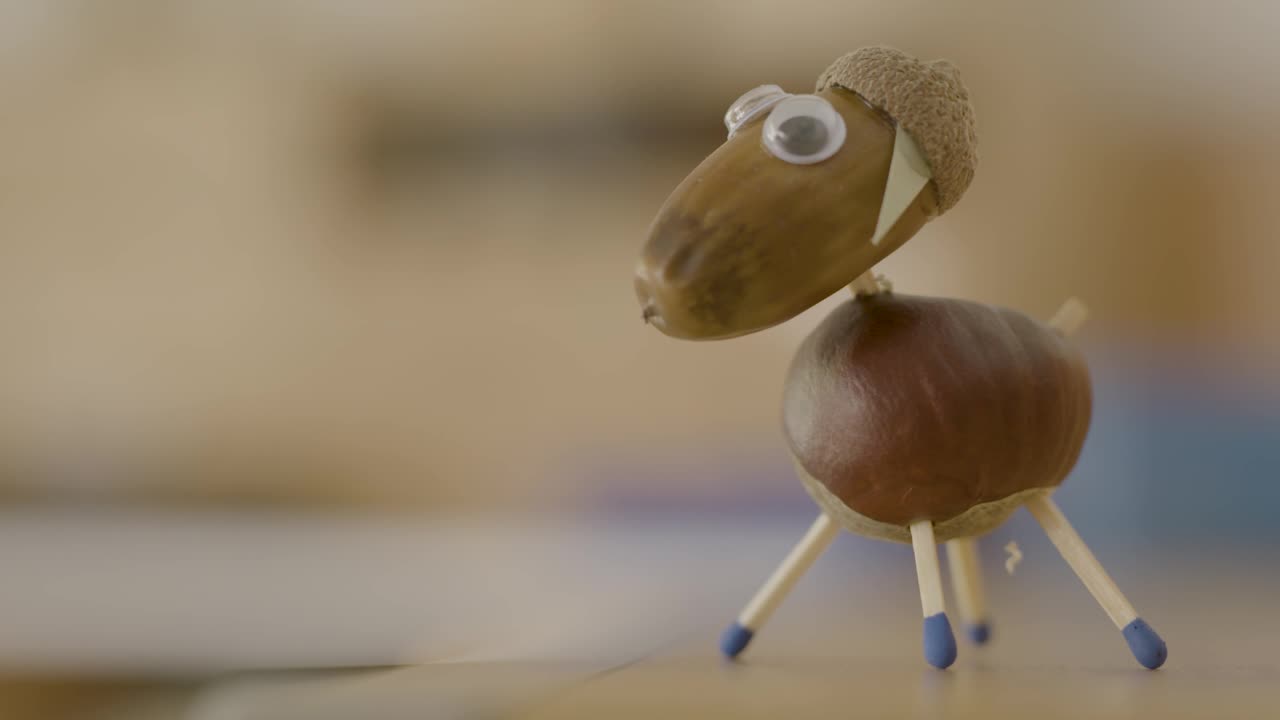 Closeup handheld handcrafted chestnut figure, kid's toy in Kindergarten, natural