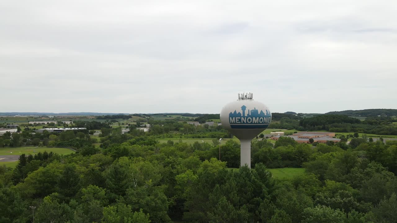 antena giratoria de la torre de agua que sostiene el tanque de agua, de pie aislada y alta en una exuberante vegetación en menominee, wisconsin, estados unidos
