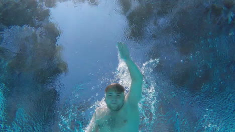 Un-Hombre-Nada-En-La-Piscina-Nada-Sobre-La-Cámara-Video-Bajo-el-agua-Cámara-Lenta