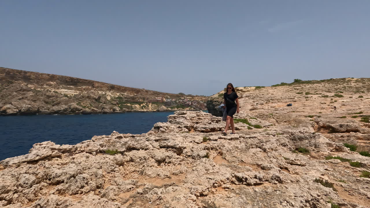 mujer joven caminando a lo largo de la costa en la isla de malta