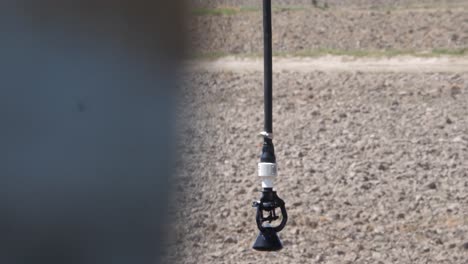 Close-up-view-of-sprinkler-pivot-at-work,-watering-crop-for-more-growth