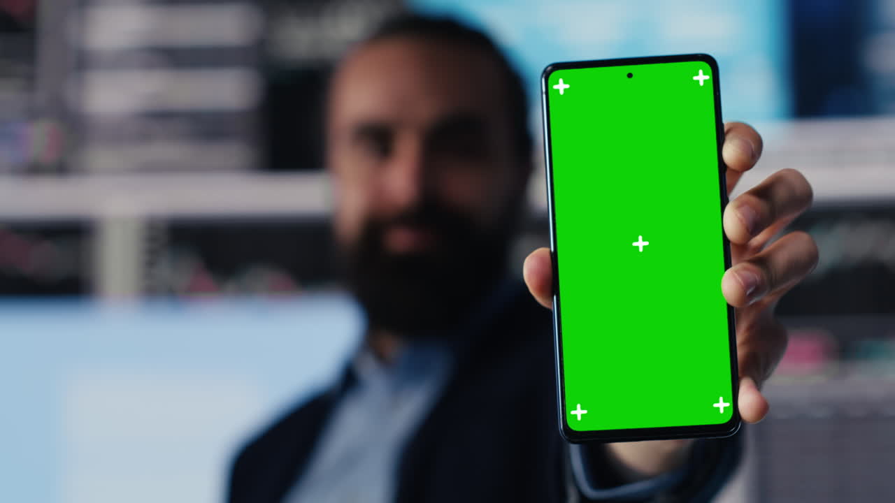 Professional man holds phone with green screen and explores strategy planning