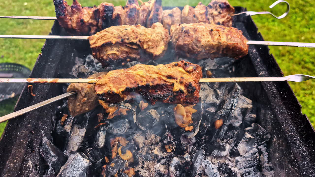 Juicy meat on wooden skewers grills over smoky flames on an outdoor barbecue setup