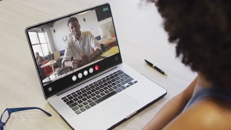 Mujer-Afroamericana-Usando-Una-Computadora-Portátil-Para-Videollamadas,-Con-Un-Colega-De-Negocios-En-La-Pantalla