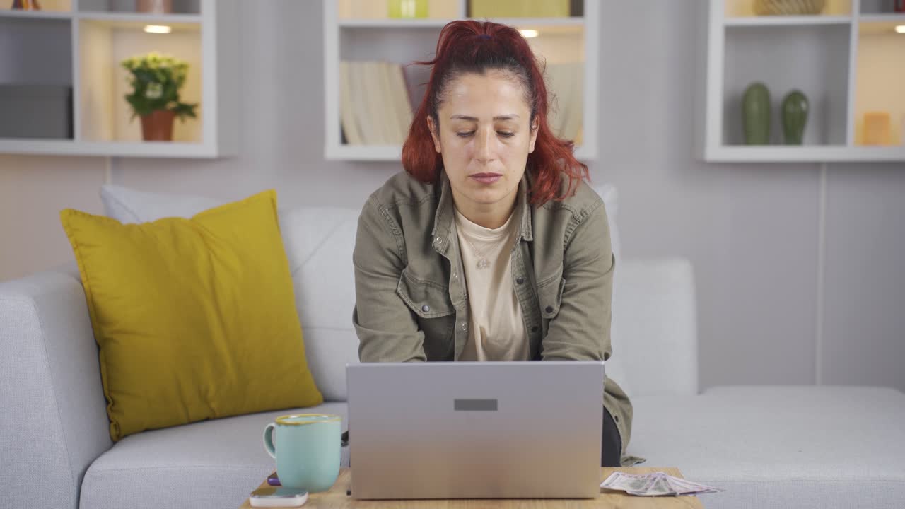 la mujer que usa la computadora portátil tiene papel moneda a su lado. compras, comercio.