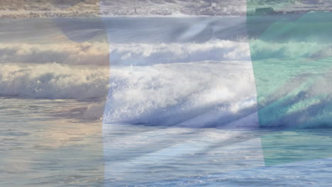 digital composition of waving ivory coast flag against waves in the sea