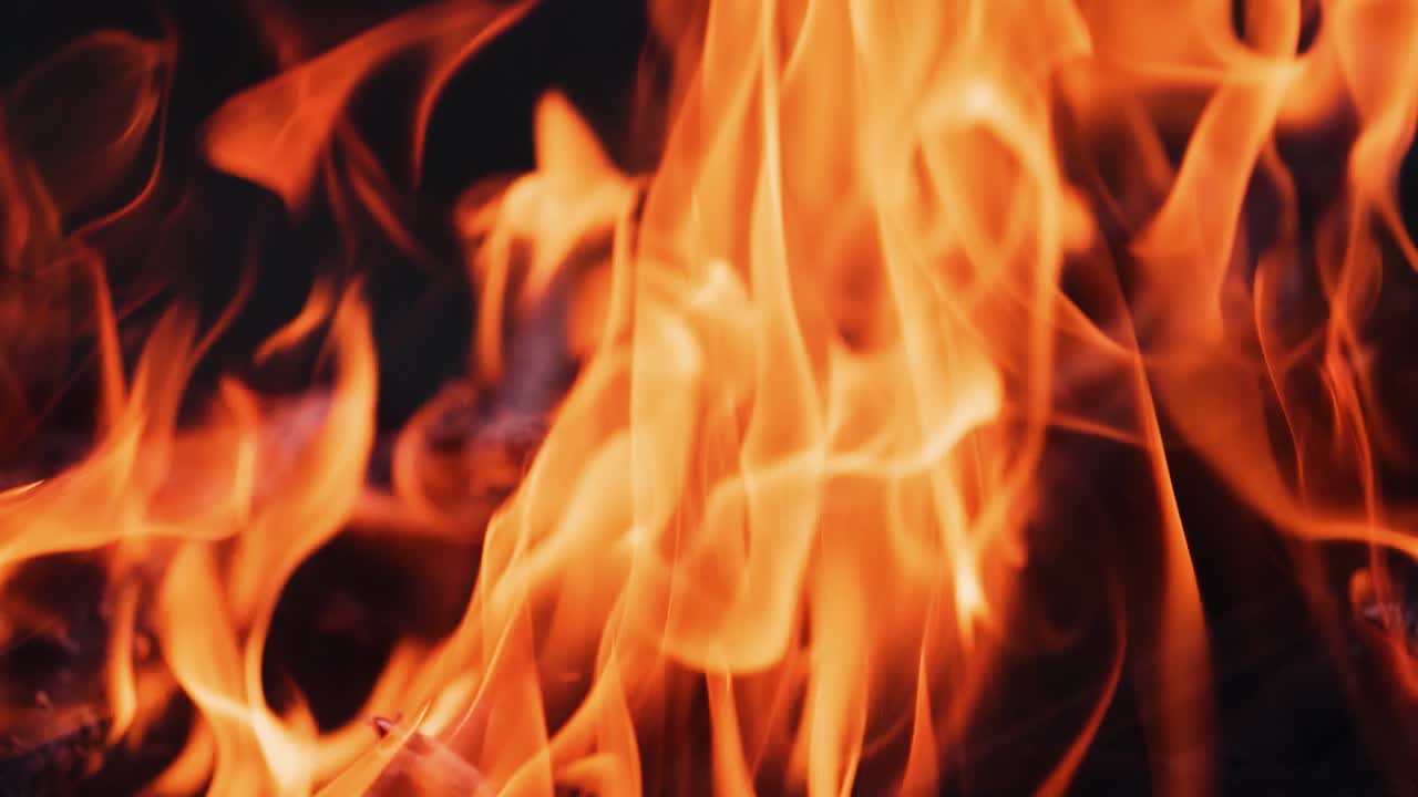 Bonfire. Burning logs in orange flames. Beautiful fire burns brightly. Embers of the fire climb up. Slow motion