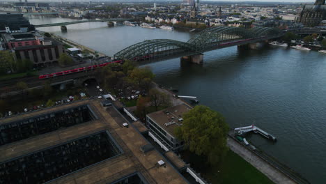 Red-passanger-trains-slowly-moving-over-the-green-Hohenzollernbrücke