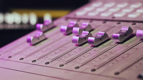 professional recording studio. interface of equipment for sound processing. fader. different modes of audio console. process of working on song or voice. neon violet knob light