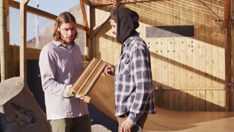 video of diverse male skateboarders talking in skate park