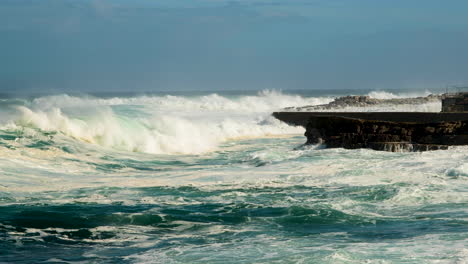 rough ocean waves rolls in and crash onto rocky coastline, hermanus