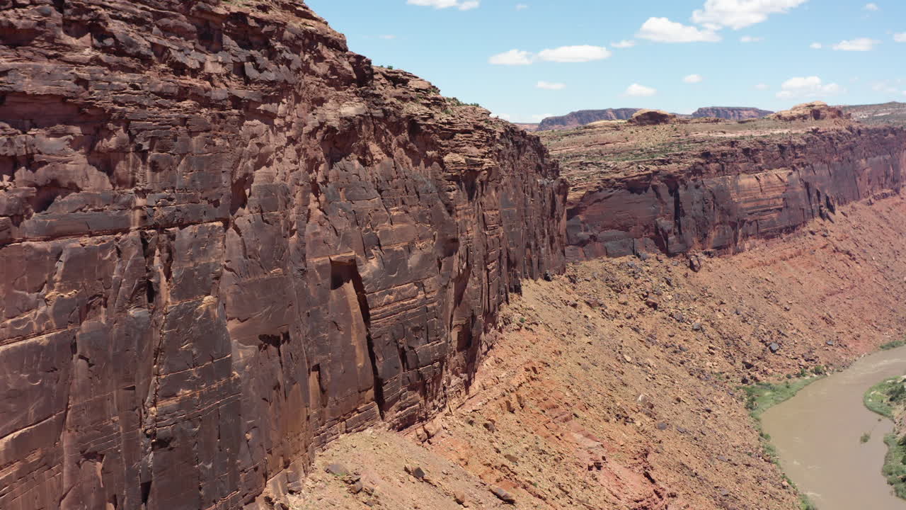 clip cinematográfico de drones moviendo parrarel a los acantilados de piedra arenisca roja en el arrecife de san rafael en utah, ee.uu.