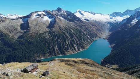 olperhutte hut y lago de montaña schlegeis en los alpes de zillertal, austria - círculo aéreo de 4k