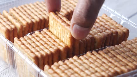 hand arranging biscuits in a plastic container