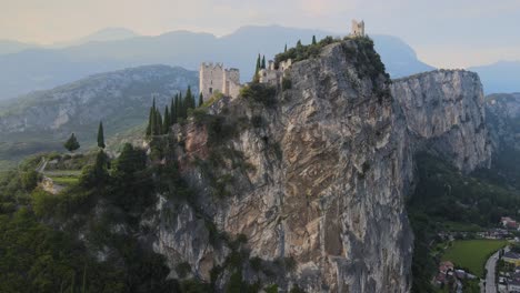 ancient arco castle on steep cliff above riva del garda city, italy