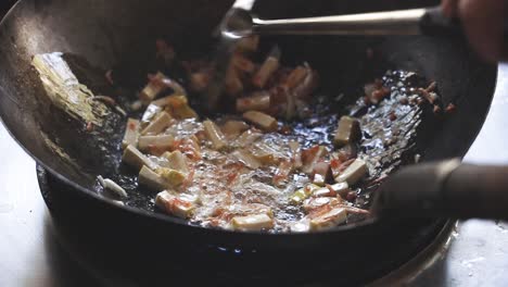 cooking pad thai series: slo mo chef stir-frying dried shrimps and tofu in hot wok at thai street food stall