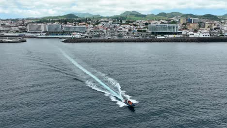 motorboat with tourists going to watch the whales leaving wake in the ocean in ponta delgada, sao miguel island, portugal