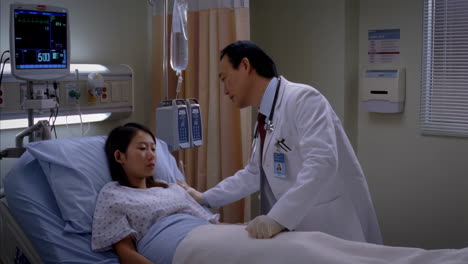 doctor consults with patient in hospital room
